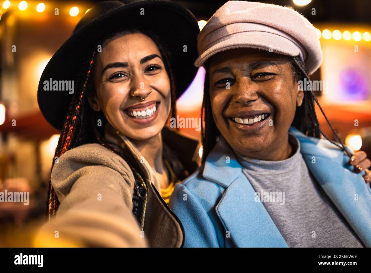 Bonne jeune fille prenant selfie avec sa mère pendant les vacances d'hiver dans la ville Banque D'Images