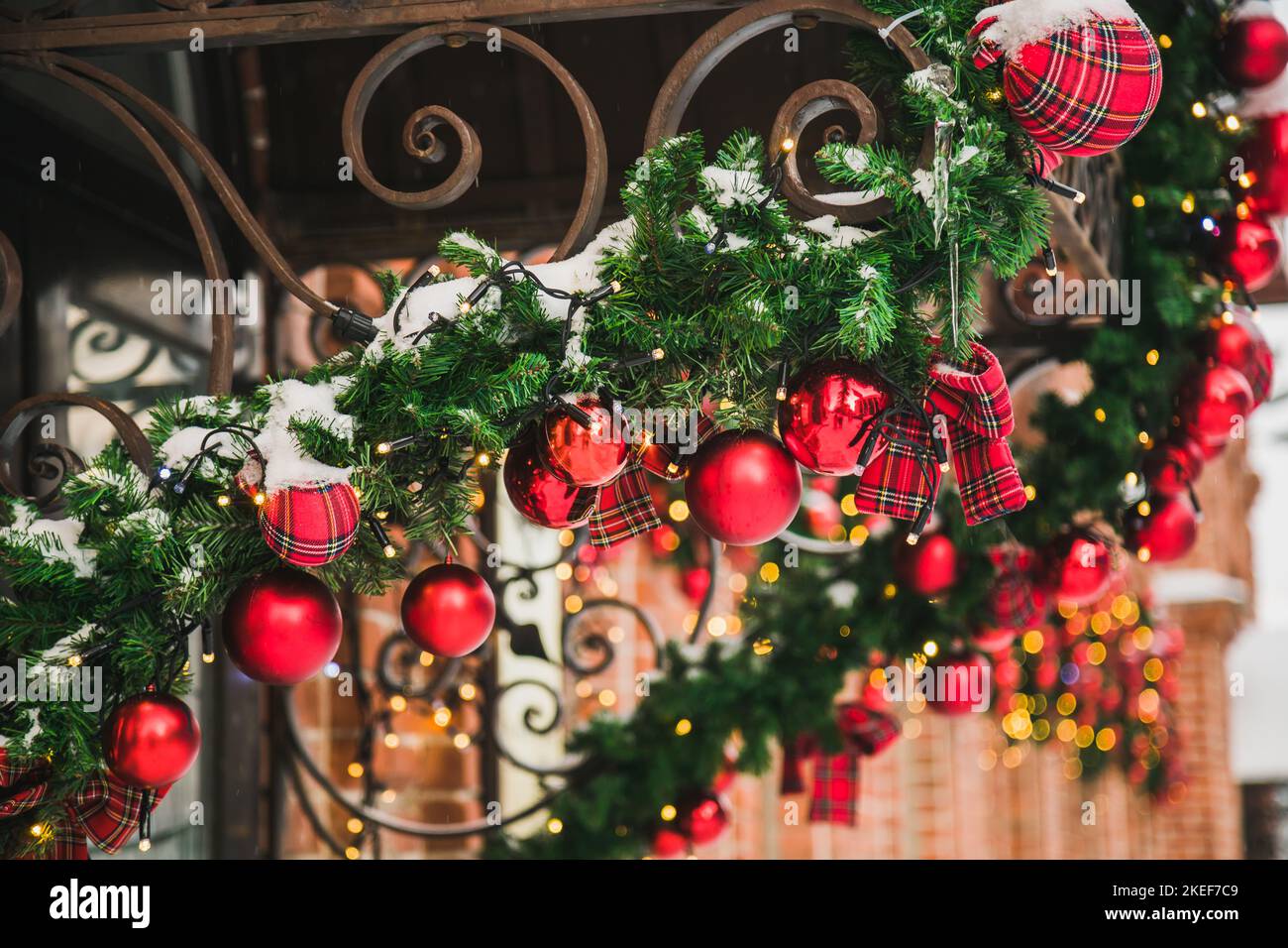 Façade du bâtiment décorée à Noël avec des branches de sapin de noël, des décorations et des guirlandes lumineuses - concept de fêtes et d'hiver Banque D'Images