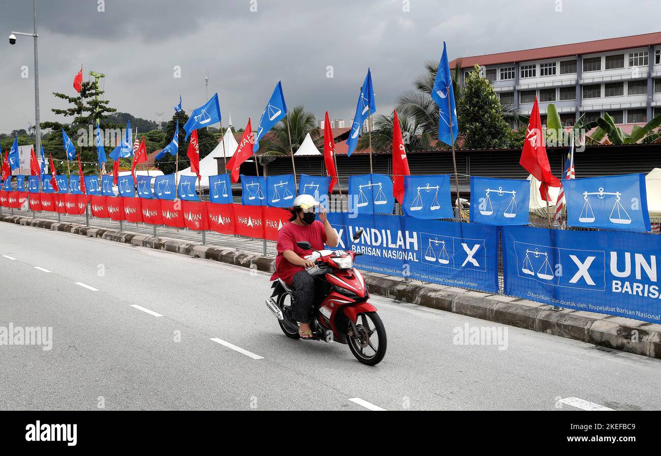 Kuala Lumpur, Malaisie. 12th novembre 2022. Un automobiliste passe devant les drapeaux des partis politiques du Front national ou du Barisan Nasional (drapeaux bleus) - le gouvernement actuel et l'Alliance de l'espoir, ou le Pakatan Harapan (drapeaux rouges) - l'opposition, à Kuala Lumpur. Les Malais se rendront aux urnes pour l'élection générale de 15th (GE15) sur 19 novembre 2022. Crédit : SOPA Images Limited/Alamy Live News Banque D'Images