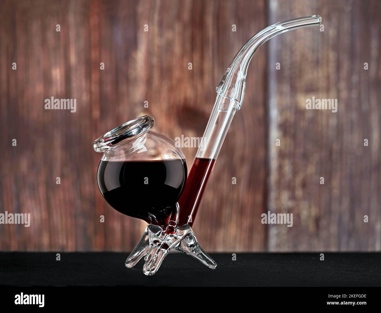 verre de vin rouge inhabituel en forme de pipe sur fond de bois, cadeau spécial drôle pour les amateurs de vin Banque D'Images