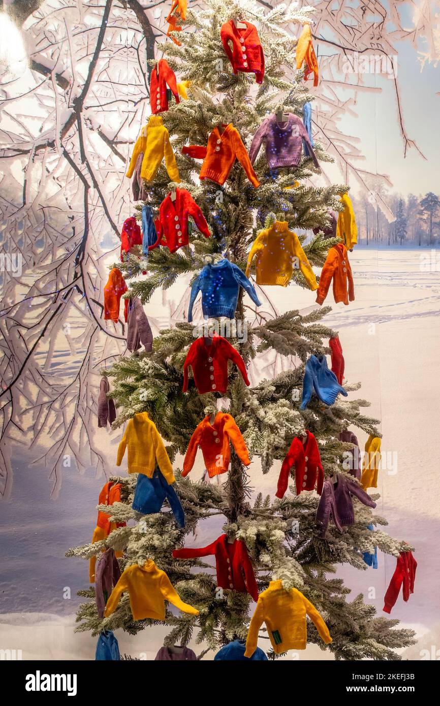 Une vitrine avec un sapin de Noël décoré de petits pulls décoratifs en laine colorée, Harrogate, North Yorkshire, Royaume-Uni. Banque D'Images