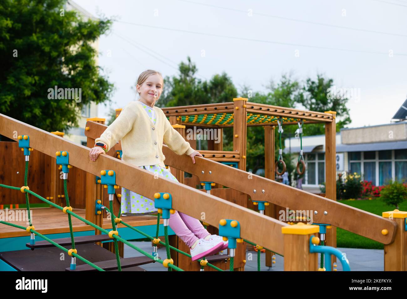 Fille enfant de l'âge de l'école élémentaire jouer et faire de l'exercice au terrain de jeu coloré de parc de la ville, activité à l'extérieur, amusement en famille Banque D'Images