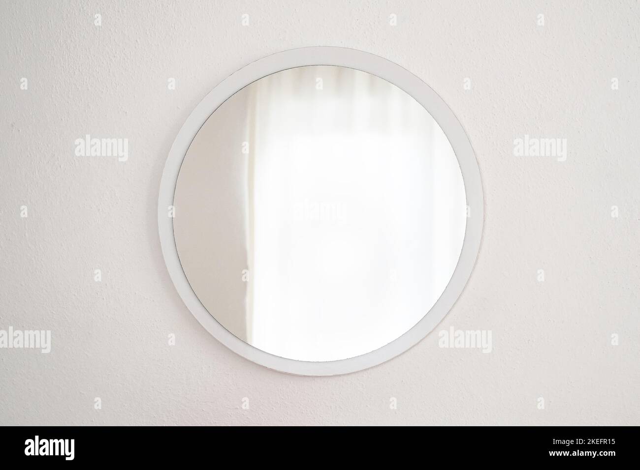 Miroir rond doré sur le mur blanc Banque D'Images
