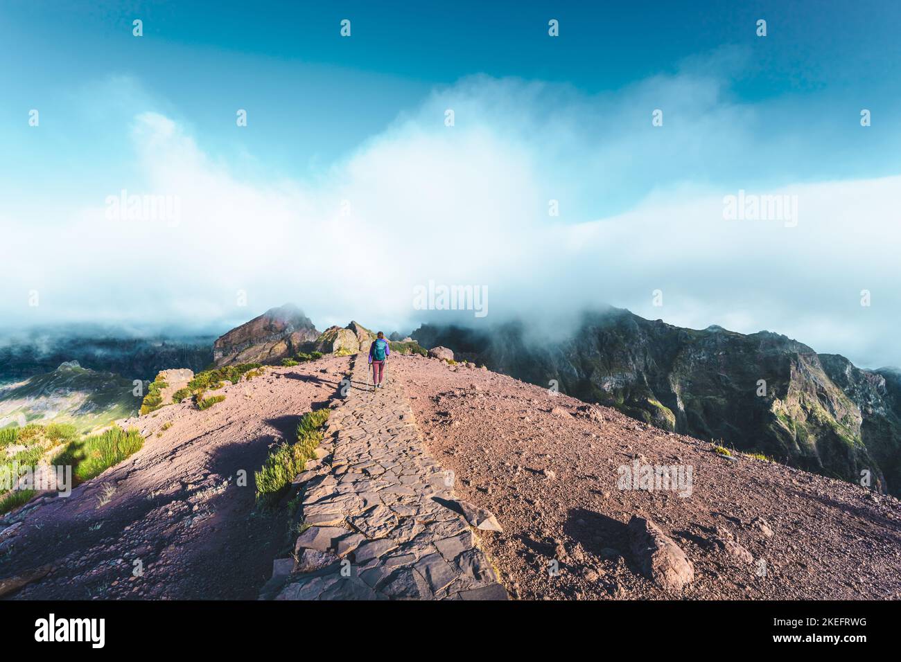 Description: Femme randonnée le long du sentier de randonnée pittoresque jusqu'à Pico Ruivo le matin. Pico do Arieiro, île de Madère, Portugal, Europe. Banque D'Images