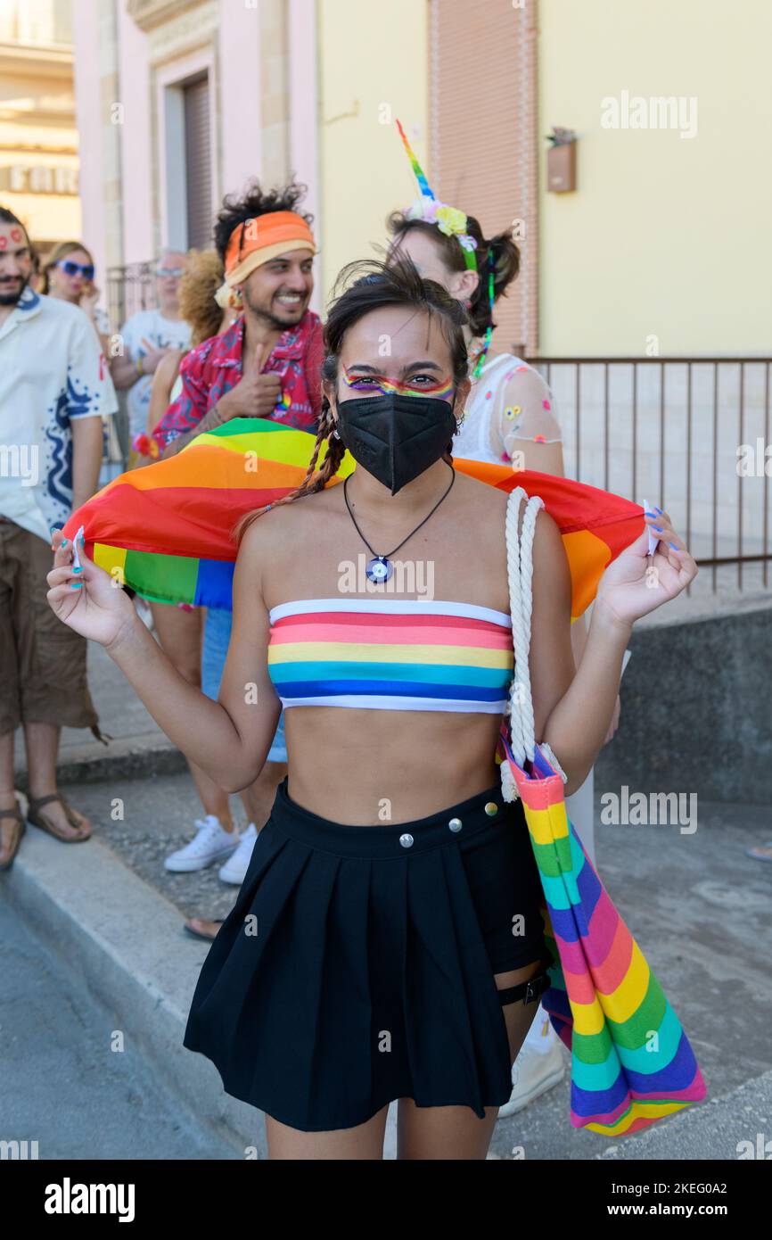 Une fille avec masque noir portant un drapeau arc-en-ciel pendant la marche de la fierté gay LGBT Banque D'Images
