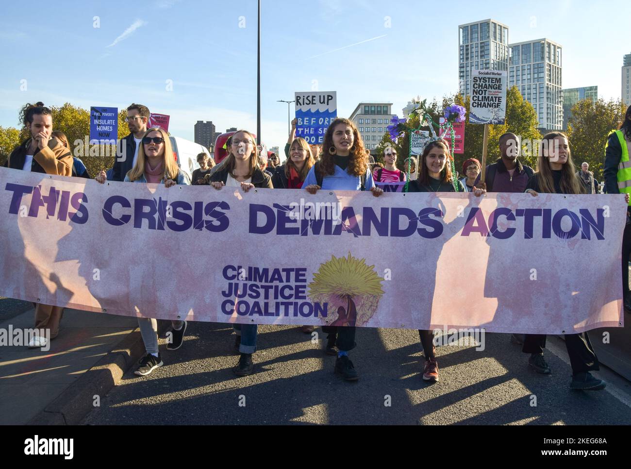 Londres, Royaume-Uni. 12th novembre 2022. Les manifestants tiennent une bannière qui indique « cette crise exige une action » lors de la manifestation sur le pont de Waterloo. Des milliers de personnes se sont rassemblées à l'extérieur du siège social de Shell à Londres et ont défilé jusqu'à Trafalgar Square dans le cadre de la Journée mondiale d'action pour la justice climatique alors que les dirigeants mondiaux se réunissent en Égypte en COP27. Crédit : SOPA Images Limited/Alamy Live News Banque D'Images
