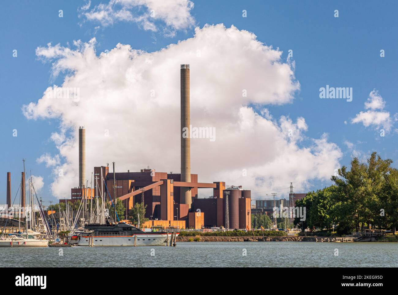 Helsinki, Finlande - 20 juillet 2022 : port de Pohjoissatama. Centrale électrique Hanasaari en pierre rouge avec cheminées hautes contre le paysage bleu. Navire à port wa Banque D'Images