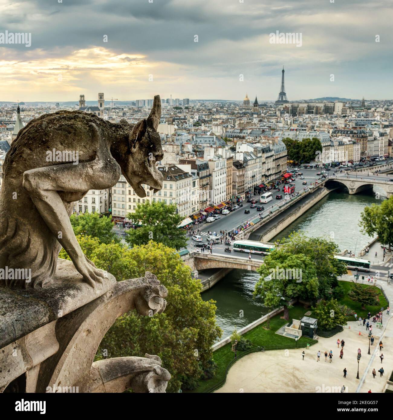 Gargoyle sur notre Dame de Paris regarde la ville, France. Vue sur la statue du gargouille gothique (chimère) au coucher du soleil. Photo de la sculpture du démon médiéval au-dessus de pari Banque D'Images
