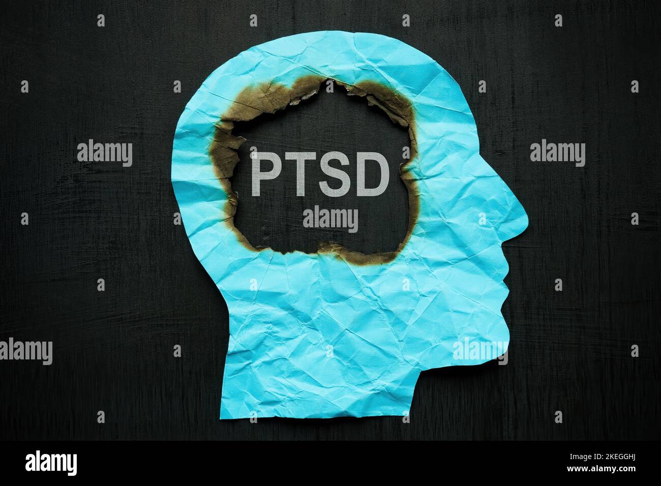 Une tête de papier brûlée à l'intérieur et une inscription PTSD. Banque D'Images