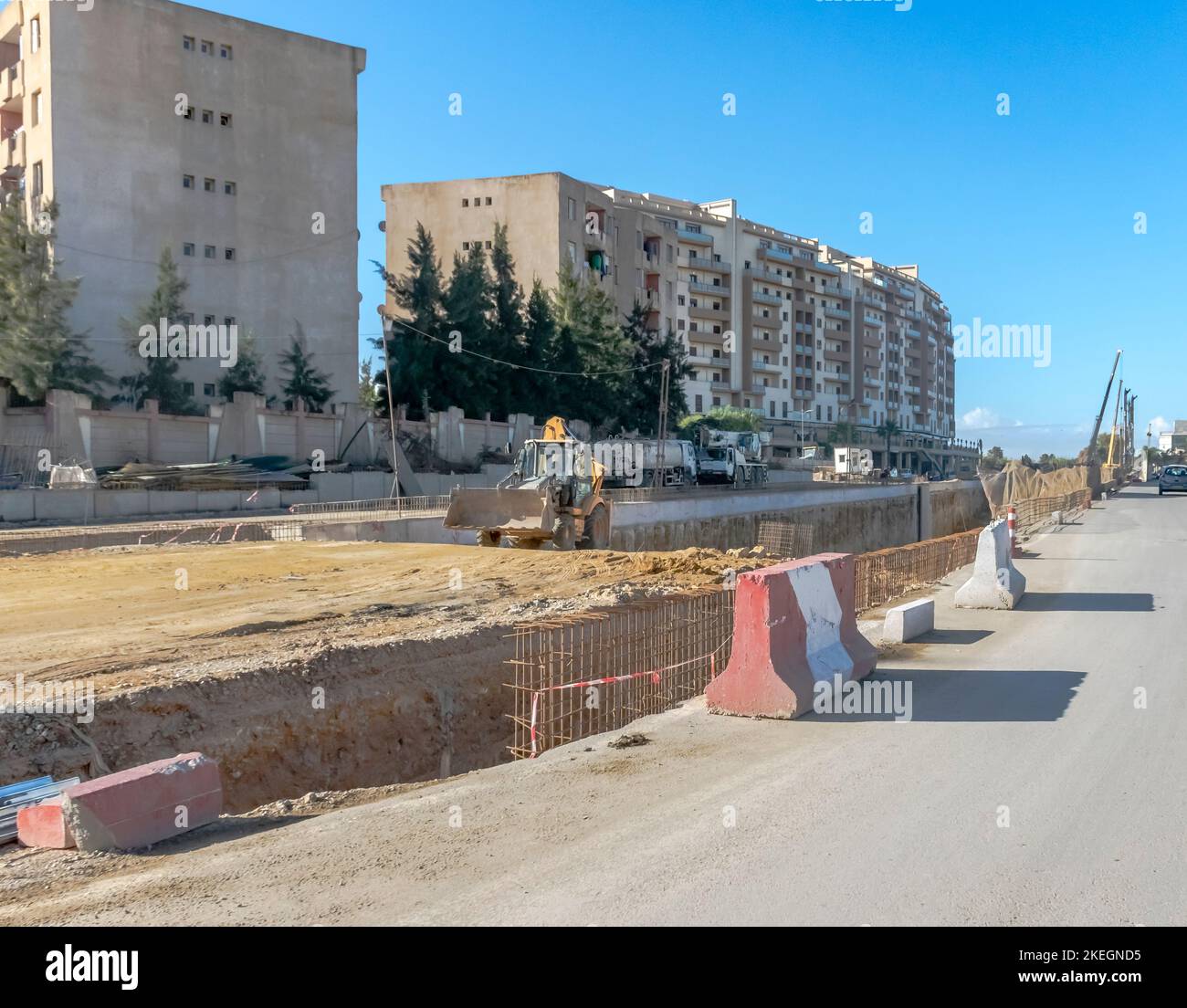 Chantier de construction de tunnel sur la route nationale RN 41. Homme conduisant une chargeuse-pelleteuse avec des machines de construction, des camions, des excavateurs et des grues. Banque D'Images