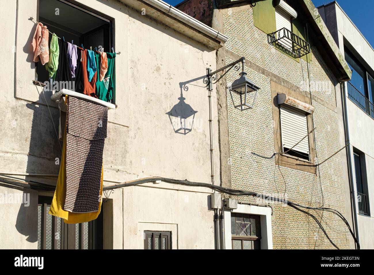 Quelques vêtements posés sur un balcon sur un mur de façade carrelé dans une scène urbaine à Porto Banque D'Images