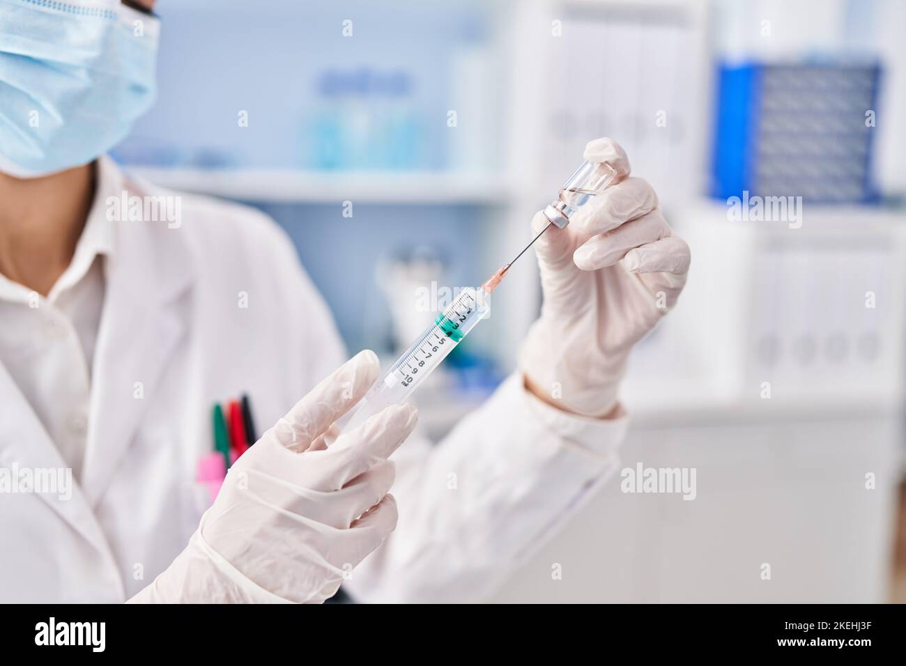 Jeune scientifique tenant un vaccin covid en laboratoire Banque D'Images