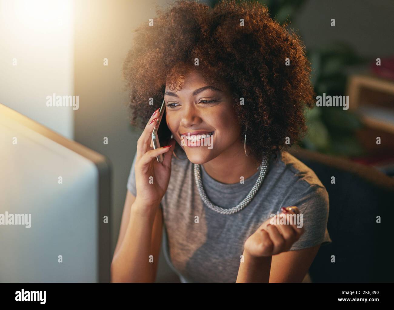 J'ai reçu l'e-mail juste en face de moi. Une jeune femme parlant au téléphone pendant un quart de travail tardif au bureau. Banque D'Images
