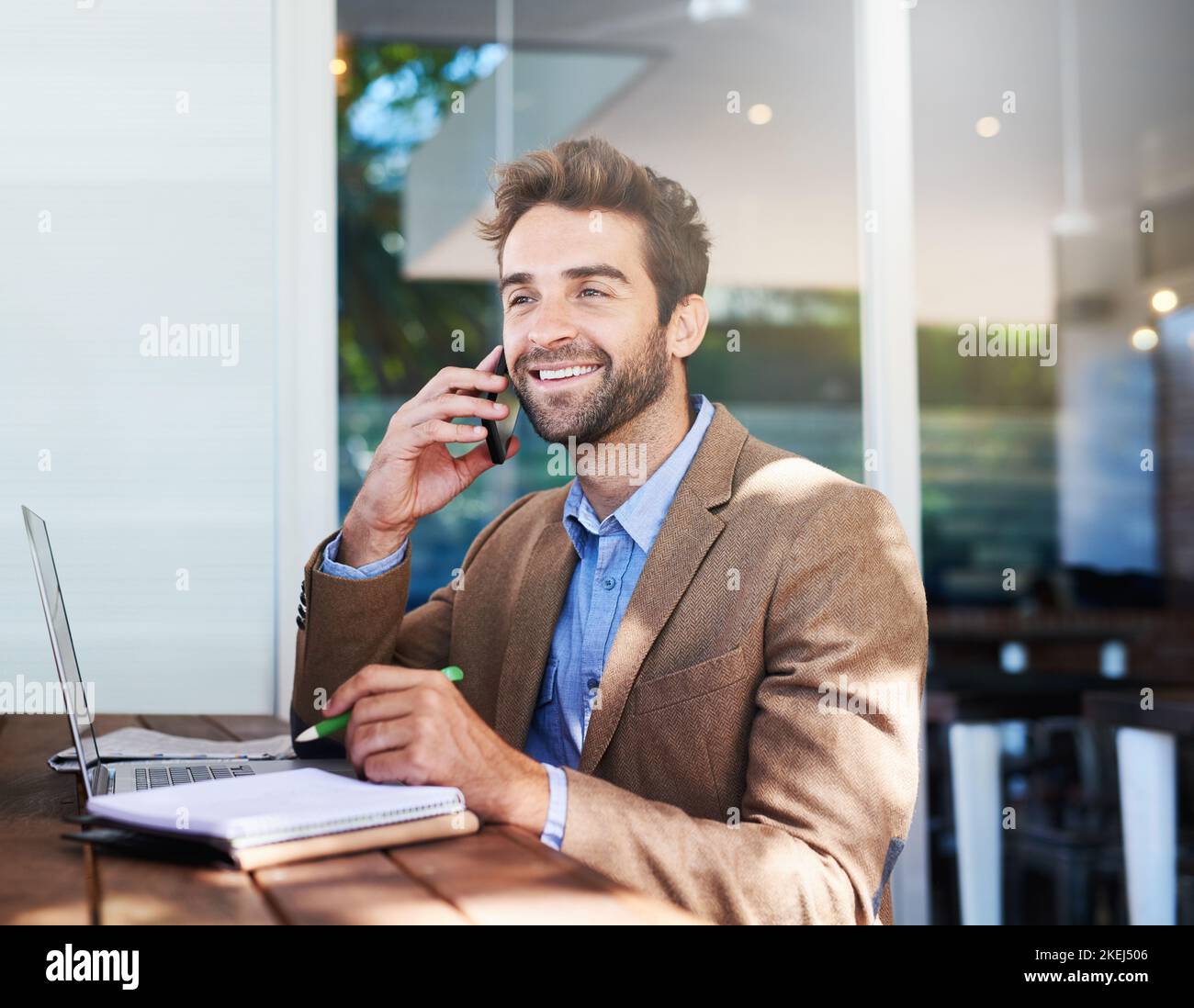 Faire des affaires n'importe où. Un jeune entrepreneur parlant au téléphone dans un café. Banque D'Images