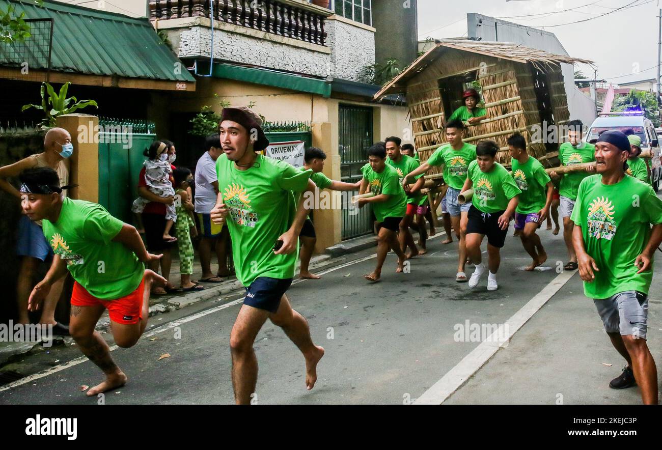 Pasig City, Philippines. 12th novembre 2022. Les résidents courent en portant une hutte faite de palmier nipa pendant la course Buhat Kubo (portant la hutte nipa) à Pasig City, aux Philippines, le 12 novembre 2022. Crédit: Rouelle Umali/Xinhua/Alamy Live News Banque D'Images