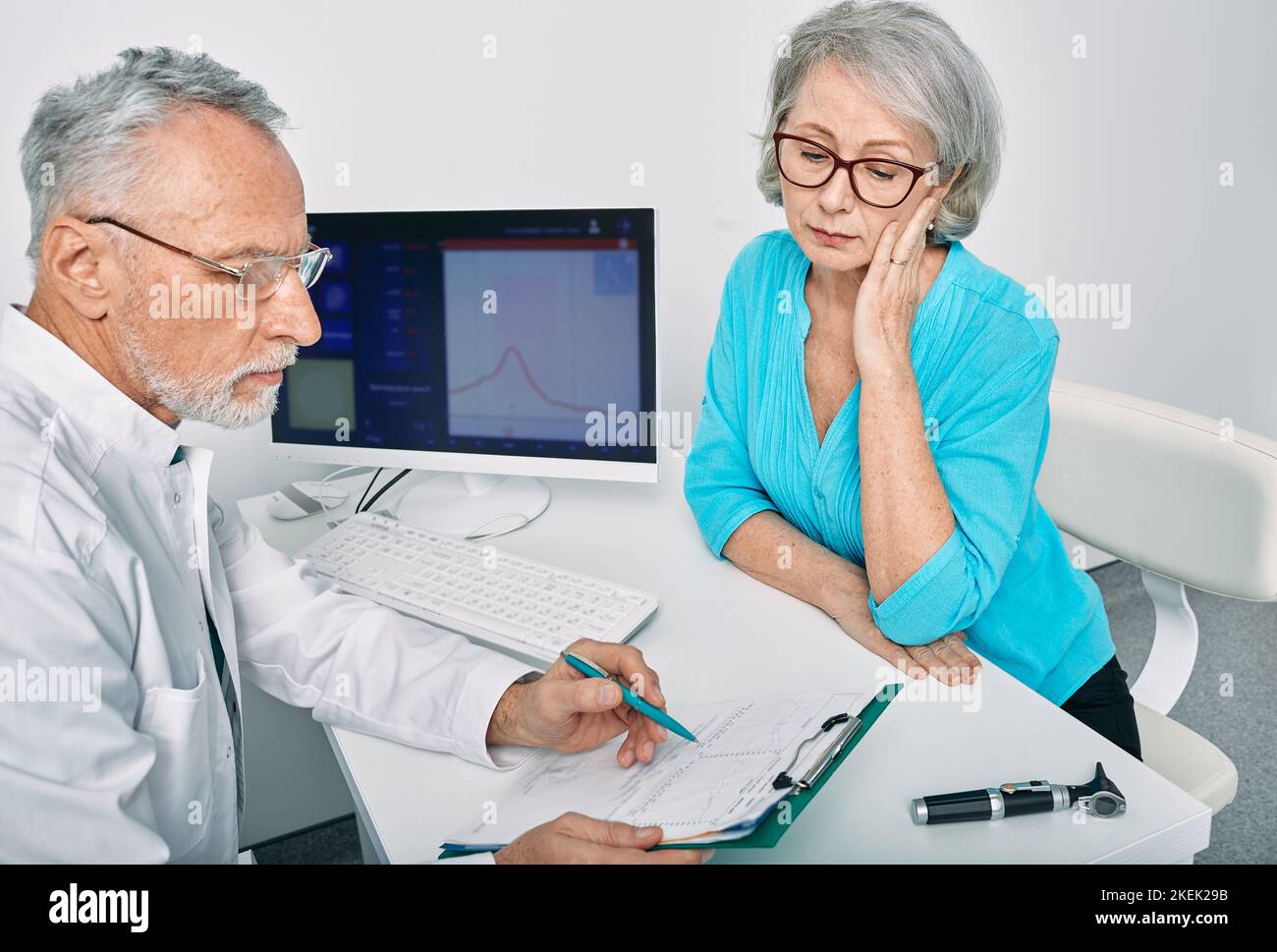 Un otolaryngologiste mature avec test d'audiométrie chez le patient consulte une femme âgée ayant des problèmes d'audition dans une clinique d'audition. Consultation d'audiologiste Banque D'Images