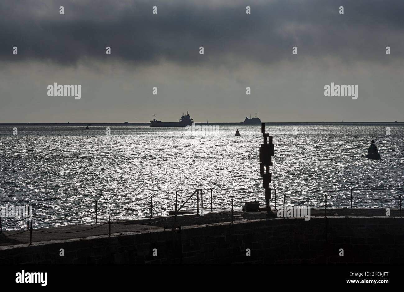 La sculpture « look II » 12ft de Sir Anthony Gormley donne sur le détroit de Plymouth depuis sa maison sur West Hoe Pier Plymouth. Dans la distance le brise-lames a Banque D'Images