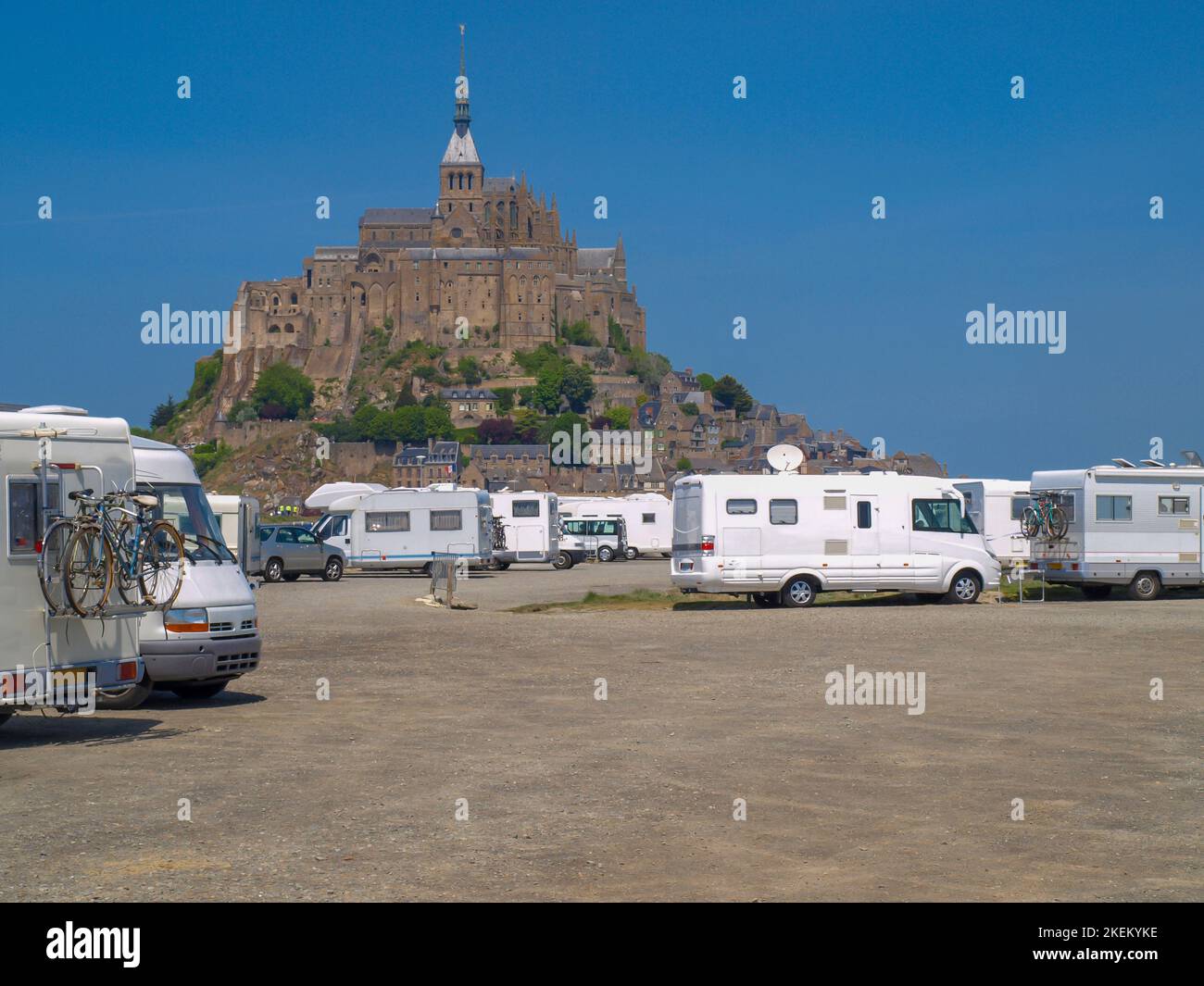 Aire de stationnement pour camping-cars avec Mont Saint Michel en arrière-plan par une journée ensoleillée avec un ciel bleu clair Banque D'Images