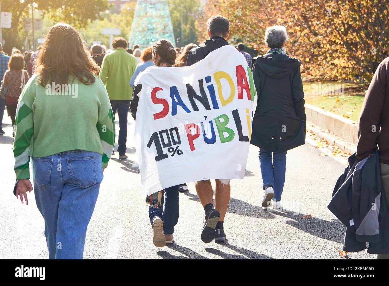 Deux jeunes manifestants en faveur de la santé publique espagnole marchent dos à dos avec la bannière "100% de santé publique" à Madrid Banque D'Images