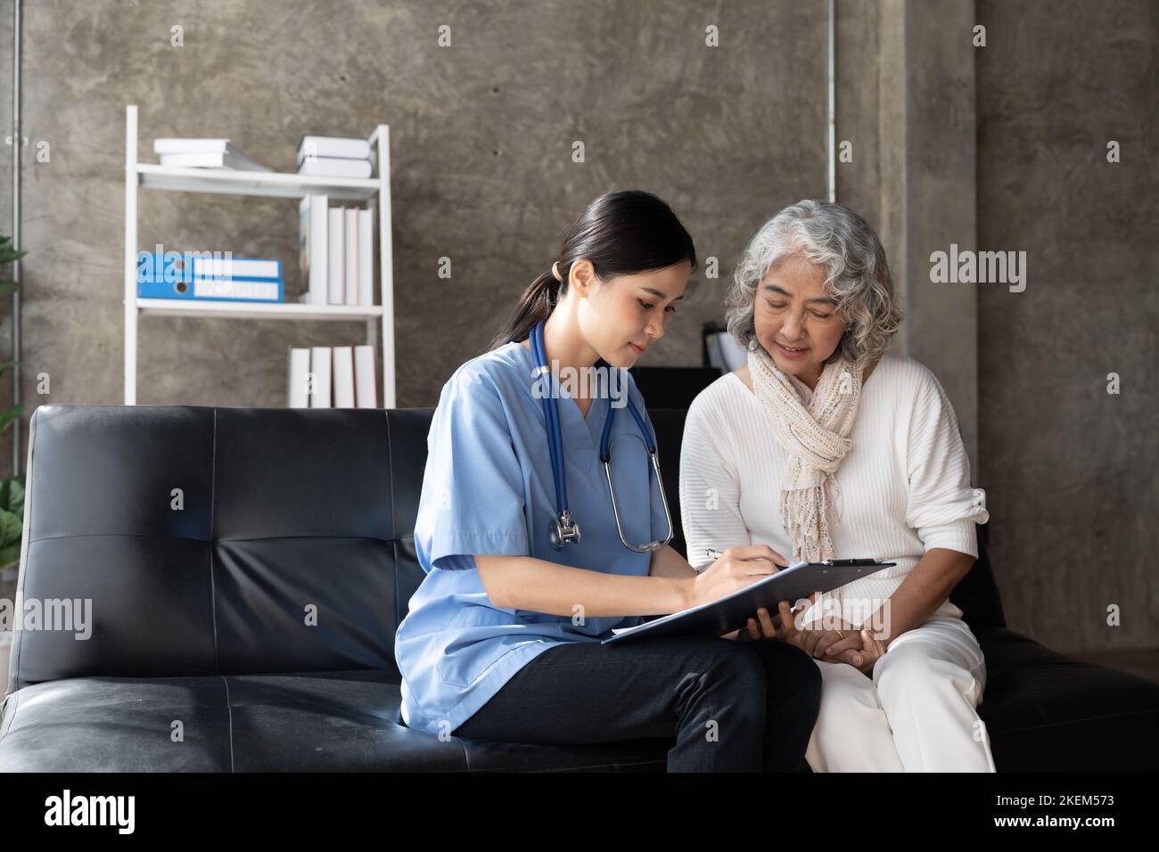 Le patient heureux tient le soignant pour une main tout en passant du temps ensemble. Femme âgée en maison de soins infirmiers et infirmière. Banque D'Images