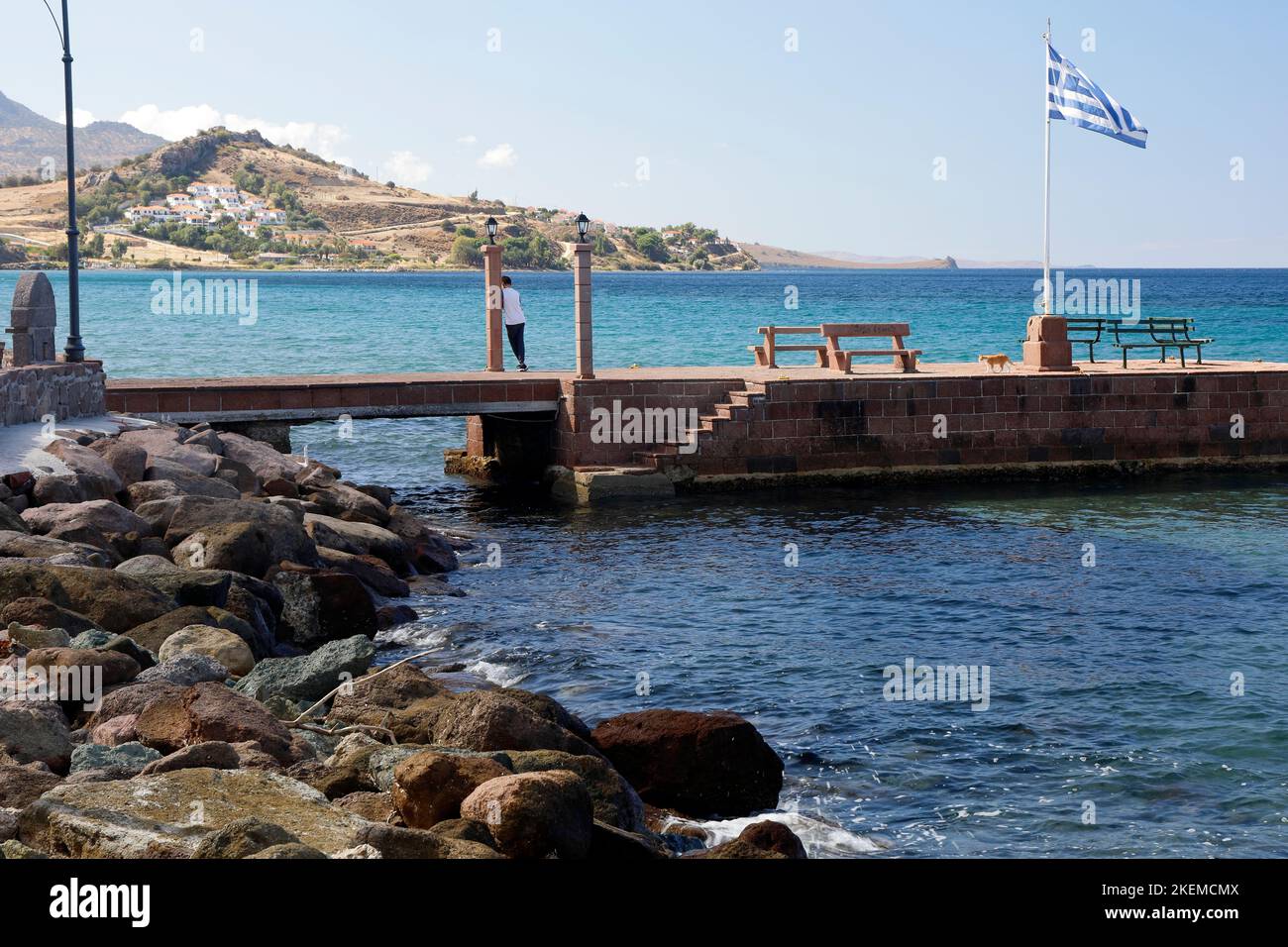 Jeune garçon et chat de gingembre sur la jetée de Petra, Lesbos Island scènes. Octobre 2022. Automne Banque D'Images