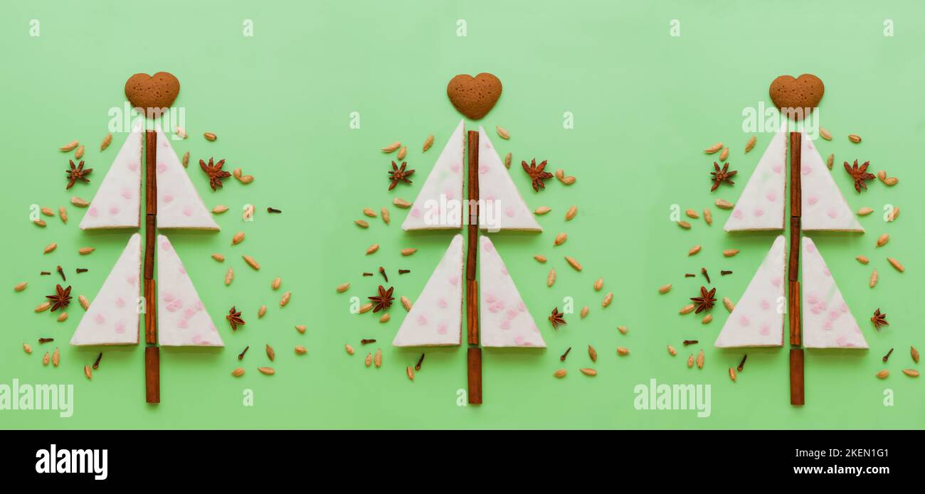 Gâteaux blancs arbre de noël en forme de biscuits au pain d'épice, anis, tarte à la cannelle plate sur le vert Banque D'Images