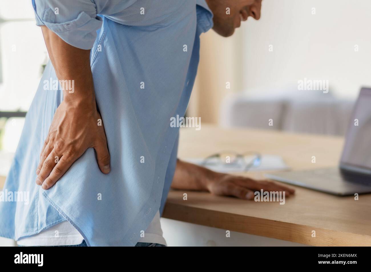 Homme se sentant mal de dos grave du long travail sédentaire à l'ordinateur dans le bureau. Mauvaise posture Banque D'Images