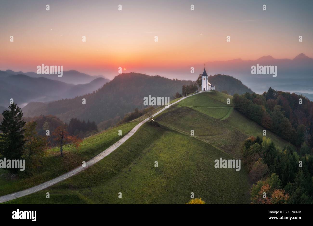 Vue aérienne de drone de petite belle église sur le sommet de la montagne en Slovénie au coucher du soleil magnifique automne matin paysage Banque D'Images