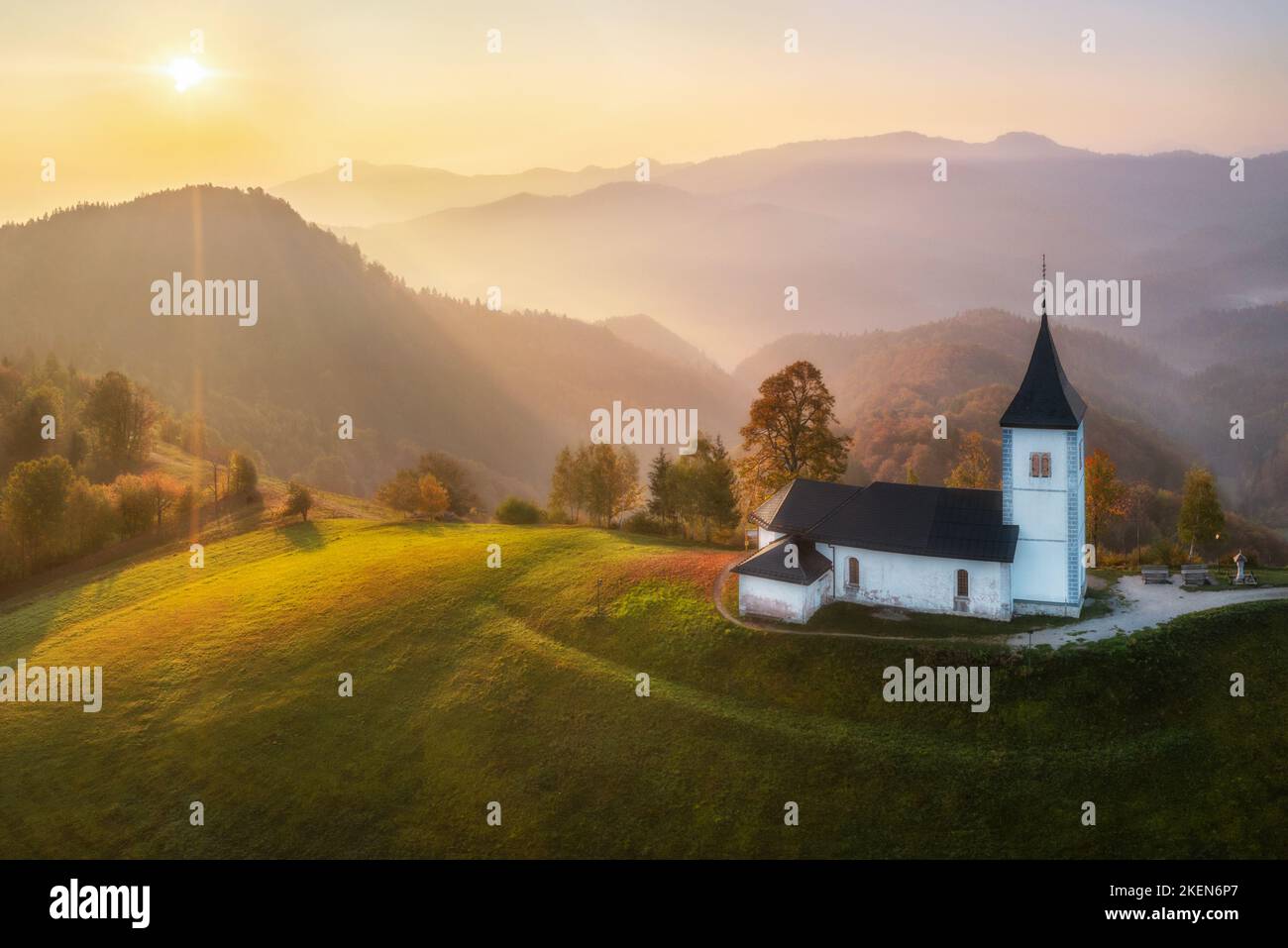 Vue aérienne de drone de petite belle église sur une montagne en Slovénie à l'aube beau paysage d'automne matin Banque D'Images