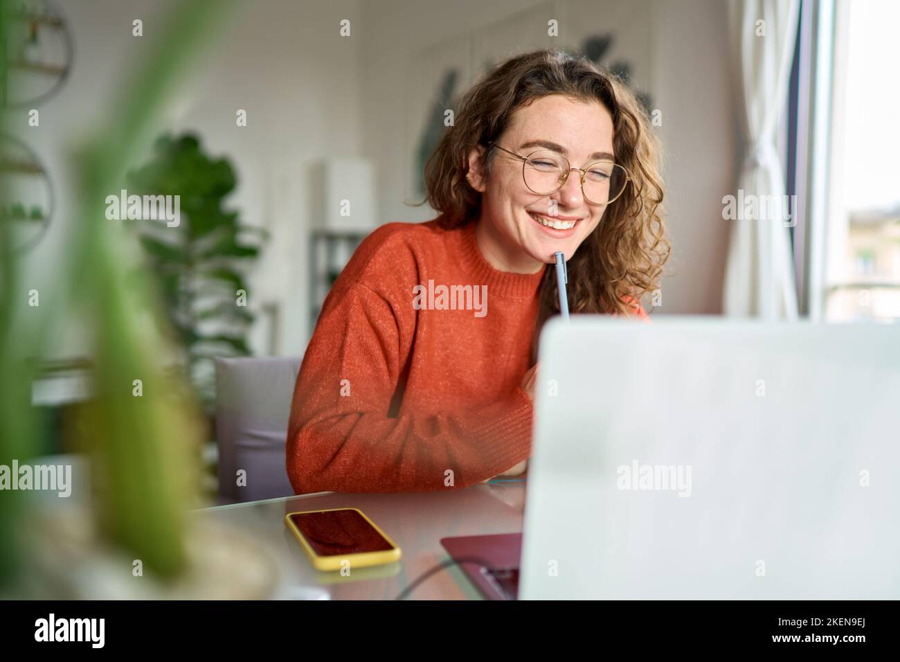 Jeune femme heureuse étudiante utilisant un ordinateur portable regardant la rédaction de webinar à la maison. Banque D'Images