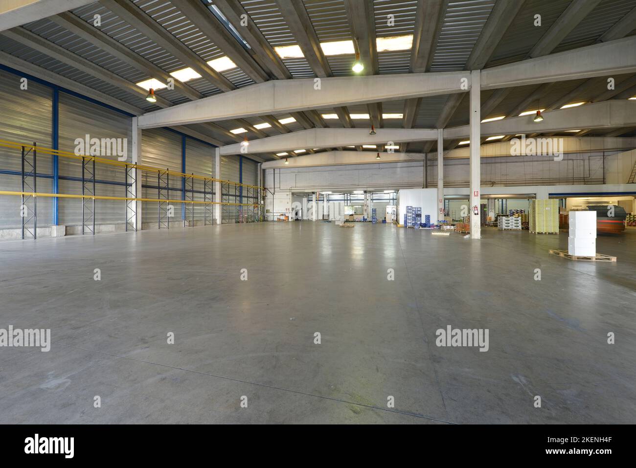Intérieur vide d'un entrepôt industriel avec sols en béton poli et nervures en béton soutenant le plafond Banque D'Images