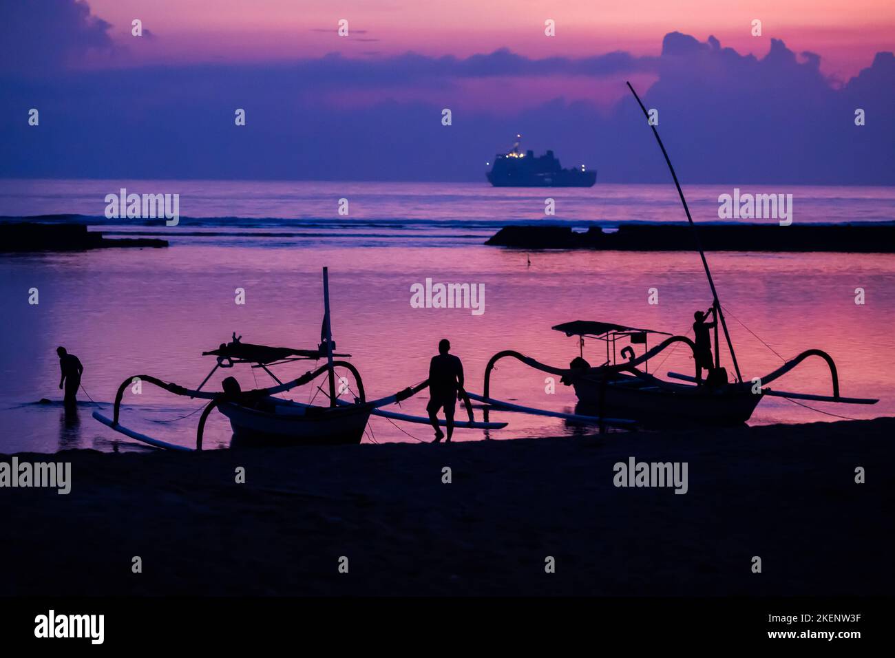 Nusa Dua, Indonésie. 14th novembre 2022. Des hommes fixent des bateaux à la plage de Nusa Dua avant le lever du soleil la veille du début du sommet de G20, avec un navire de la Marine indonésienne visible en arrière-plan. La réunion du groupe G20, les pays industrialisés et les économies émergentes les plus forts, aura lieu les 15 et 16 novembre. Credit: Christoph Soeder/dpa/Alay Live News Banque D'Images