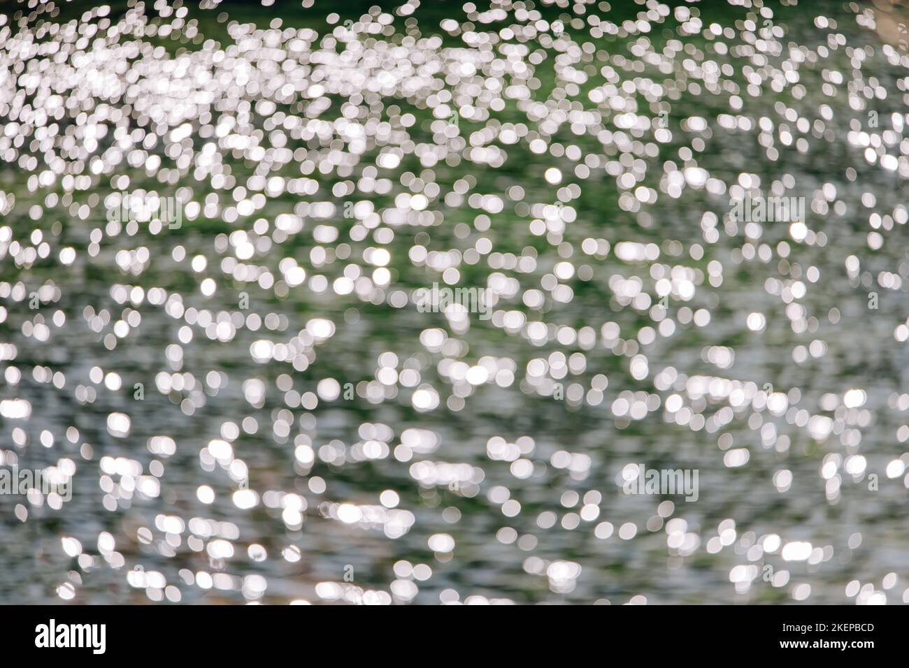 Surface d'eau floue avec des reflets du soleil, arrière-plan abstrait, réflexion sur l'eau, jour ensoleillé Banque D'Images
