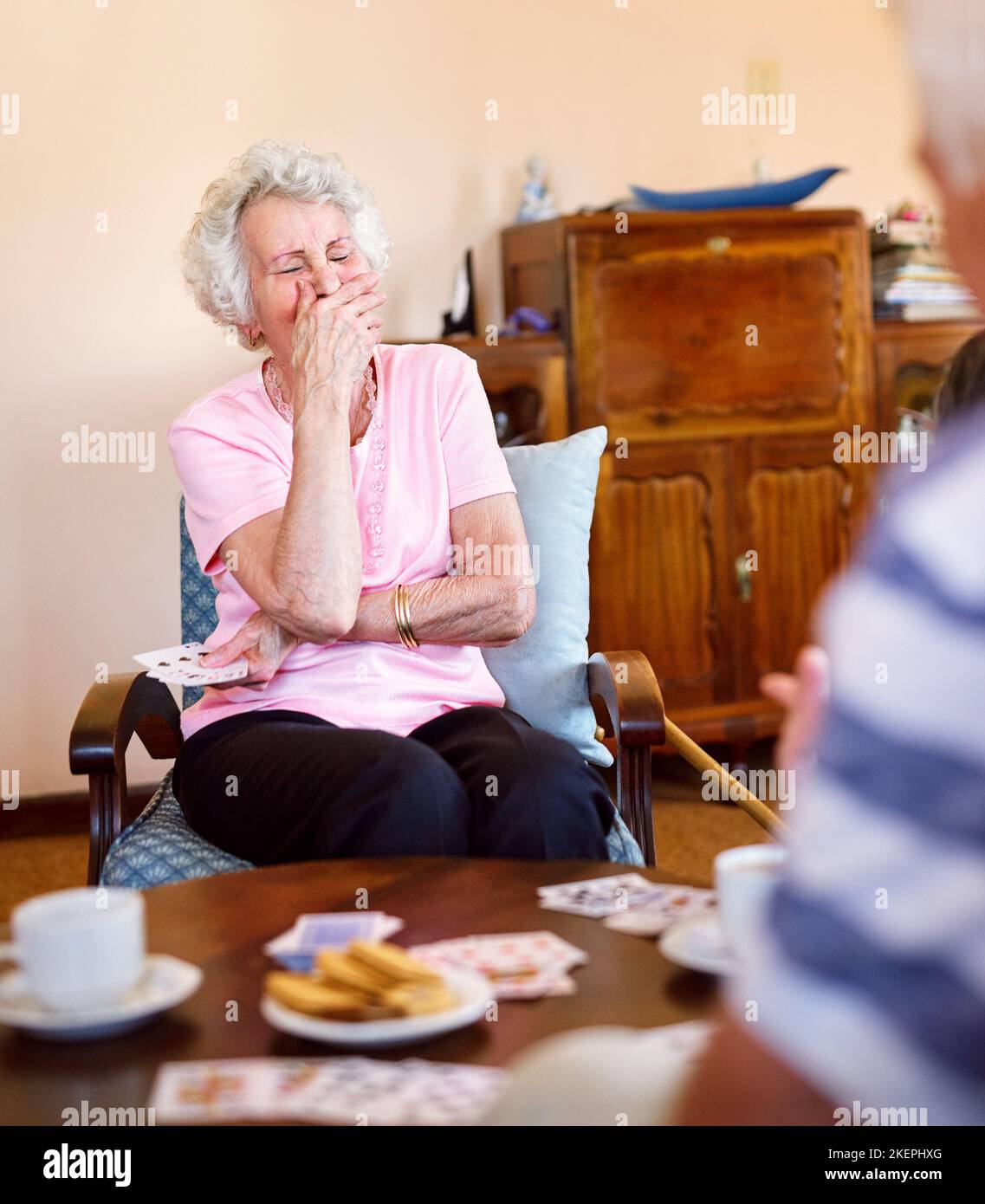 Les theres encore beaucoup à rire. Une femme âgée heureuse riant pendant un jeu de cartes avec ses amis dans une maison de retraite. Banque D'Images