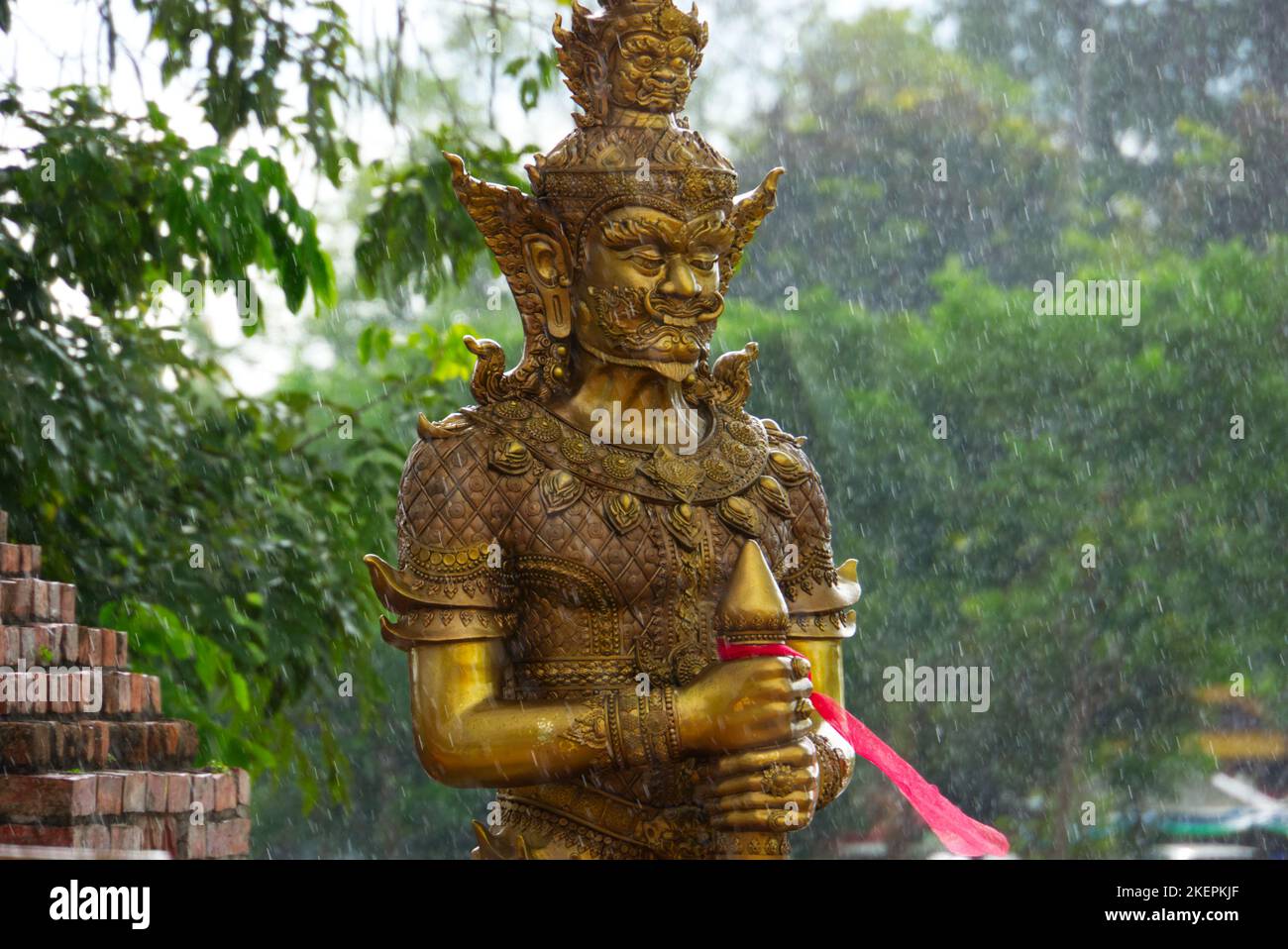 Thaïlande Vessavana déité de la richesse et de la protection, un dieu de la richesse en texture or avec des arbres et de la pluie en arrière-plan. Banque D'Images