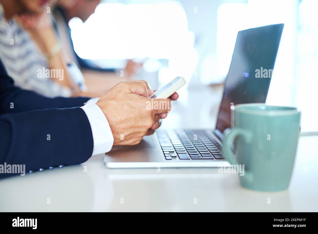Rester à proximité de son réseau d'affaires. Un homme d'affaires utilisant son téléphone et son ordinateur portable dans un bureau. Banque D'Images
