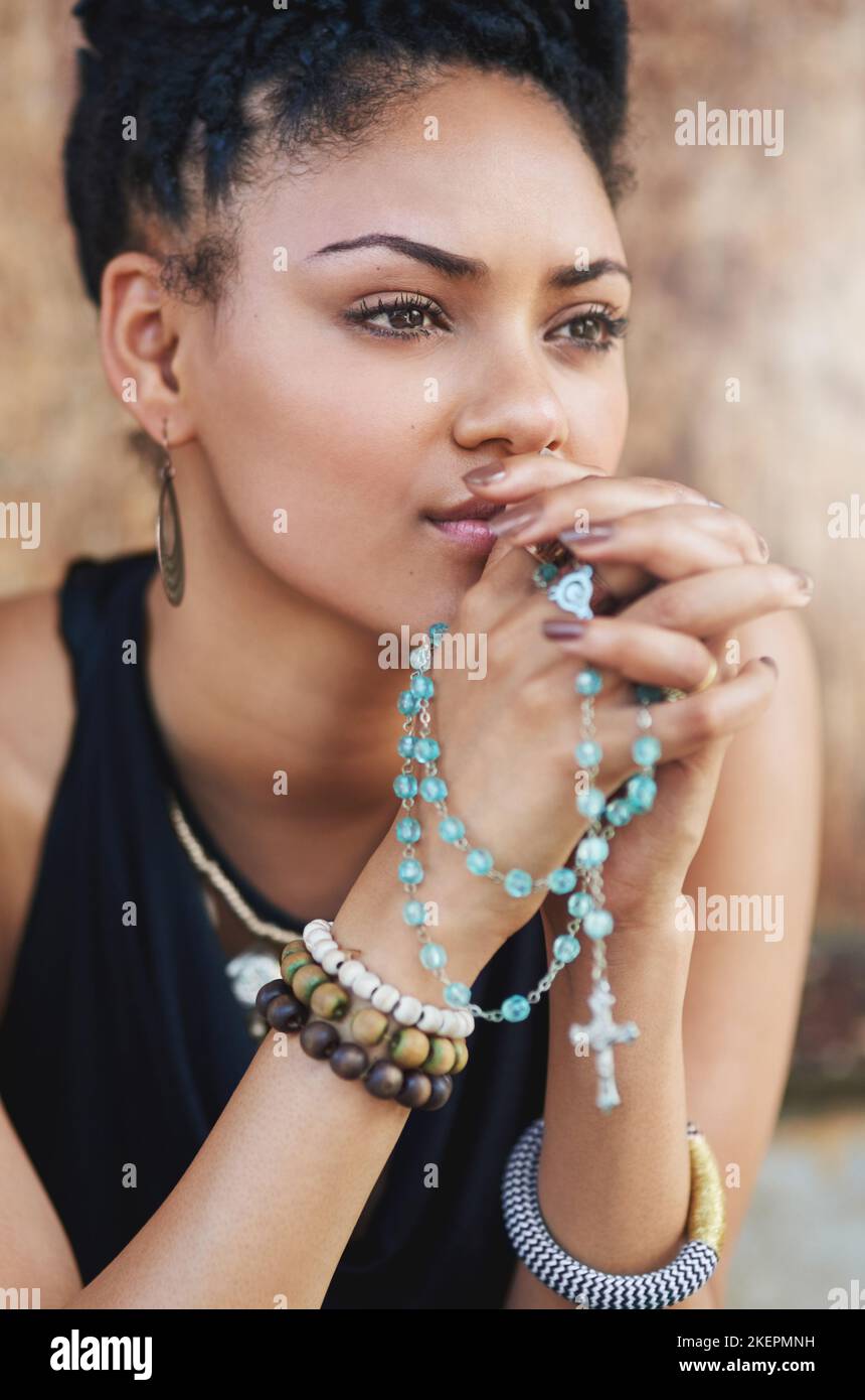 Theres toujours le temps de prier. Une jeune femme attrayante priant avec son rosaire dehors. Banque D'Images