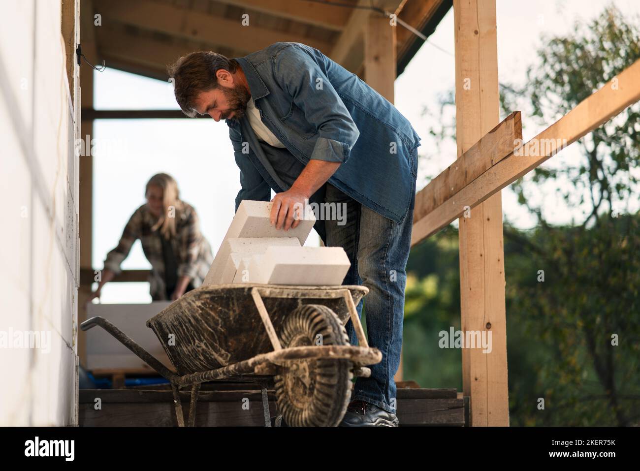 Homme mature travaillant sur le chantier de construction de leur nouvelle maison. Banque D'Images