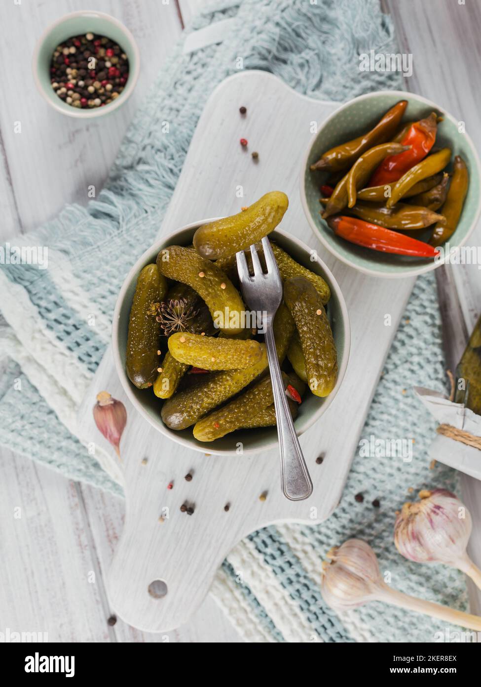 Conserver les concombres marinés, le poivre, les assaisonnements et l'ail sur une table en bois blanc. Aliments fermentés sains. Légumes en conserve à la maison. Banque D'Images