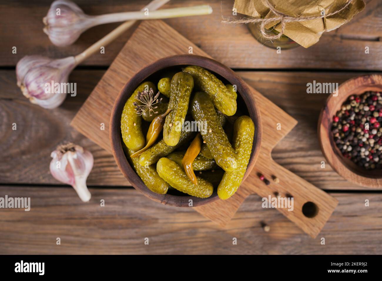 Conserver les concombres marinés, les assaisonnements et l'ail sur une table en bois. Aliments fermentés sains. Légumes en conserve à la maison. Banque D'Images