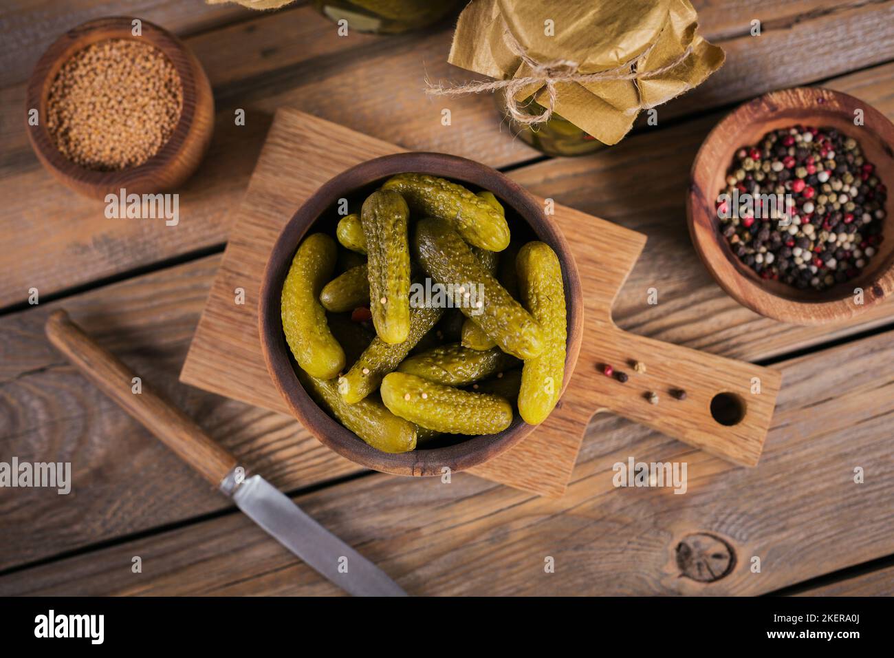 Conserver les concombres marinés, les assaisonnements et l'ail sur une table en bois. Aliments fermentés sains. Légumes en conserve à la maison. Banque D'Images
