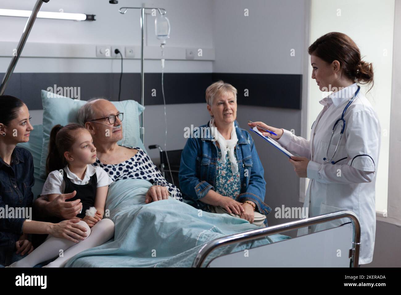 Médecin gériatrique effectuant un examen médical de routine de patient âgé hospitalisé. Femme généraliste déclarant l'état de santé du grand-père à la famille dans la chambre d'hôpital. Banque D'Images