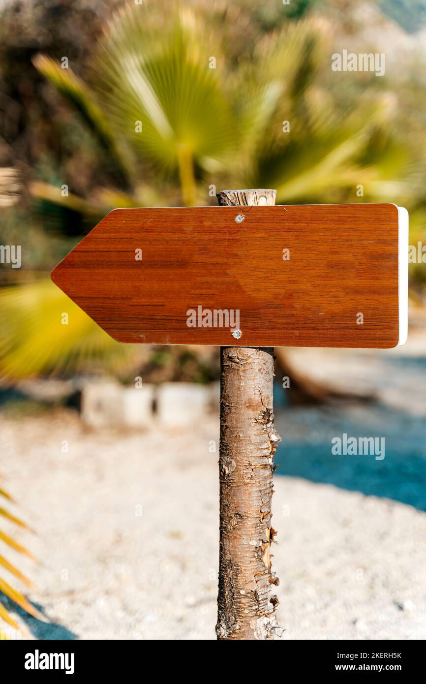 Panneau vierge sur la plage d'été. Un guide d'information en bois vide sur le trajet. Destination, concept de choix. Photo de haute qualité Banque D'Images