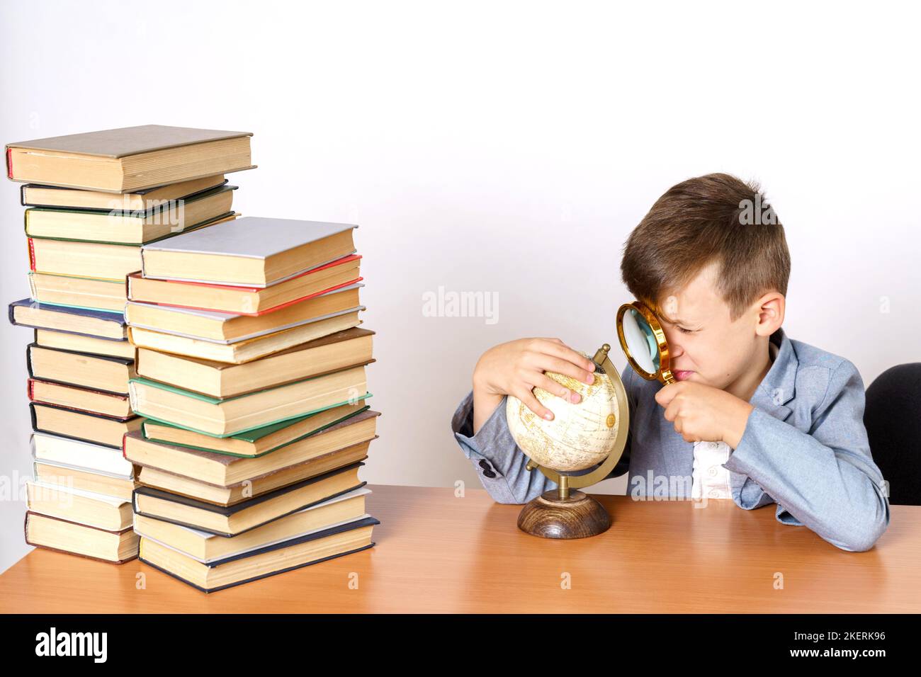 Concept d'éducation. L'étudiant fait ses devoirs, étudie le monde entier. Il a des livres des deux côtés. Banque D'Images