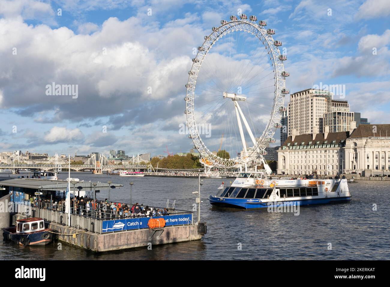 Un bateau City Cruises s'embarque sur l'embarcadère de Westminster avec des touristes et des visiteurs qui attendent à bord et le London Eye en arrière-plan. Londres Banque D'Images