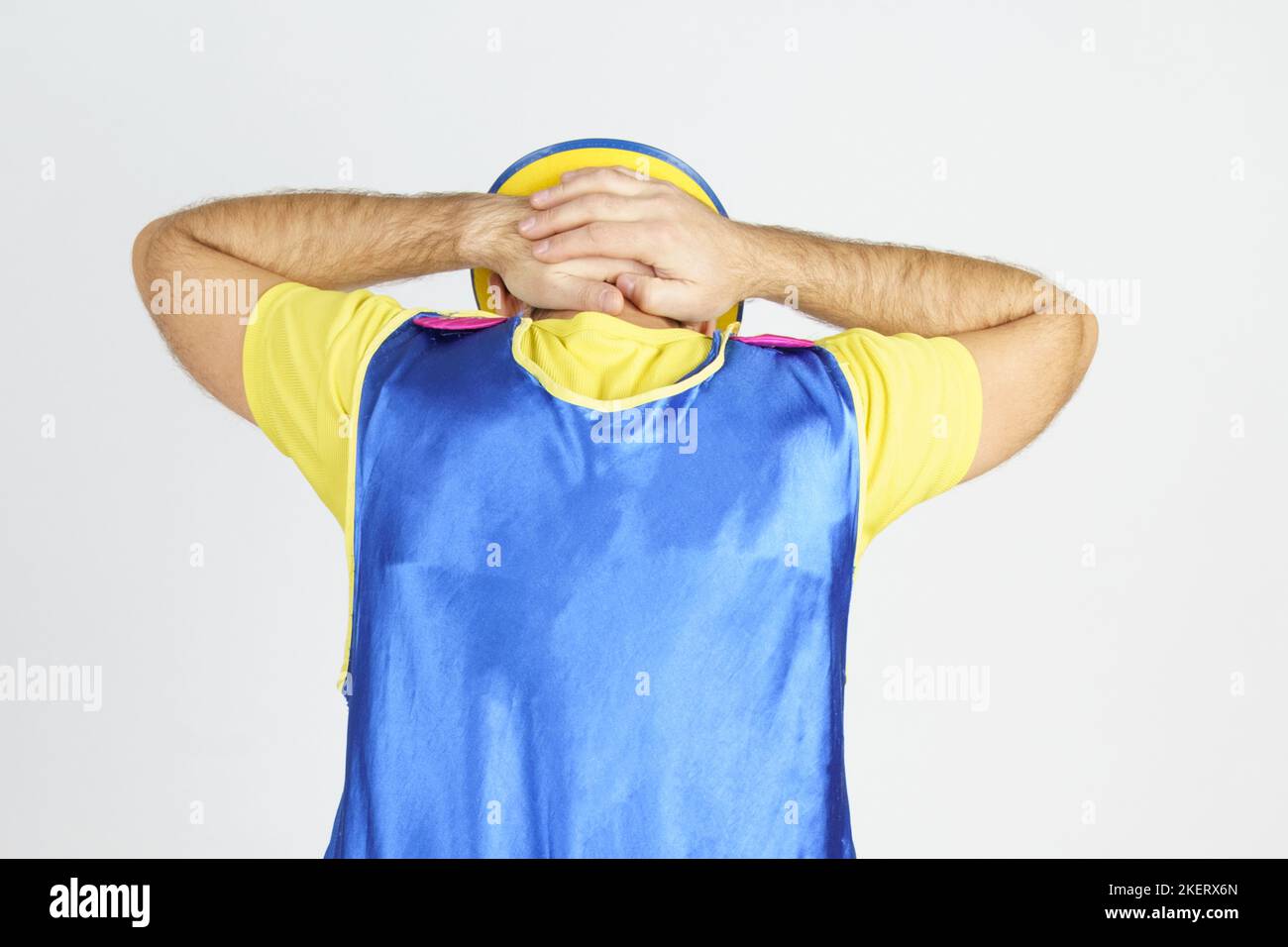 Concept de vacances. Le clown se tient avec son dos à la caméra, tient ses mains derrière sa tête - arrêté Banque D'Images