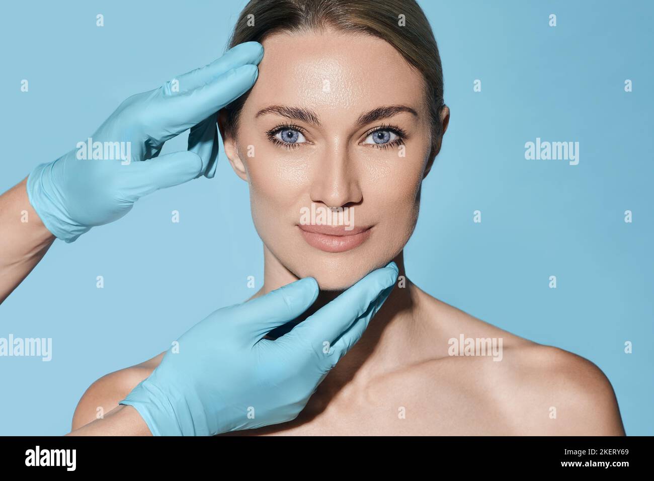Forme idéale de visage de femme pour chirurgien plastique, référence visage de femme sur fond bleu. Chirurgie plastique, concept Banque D'Images