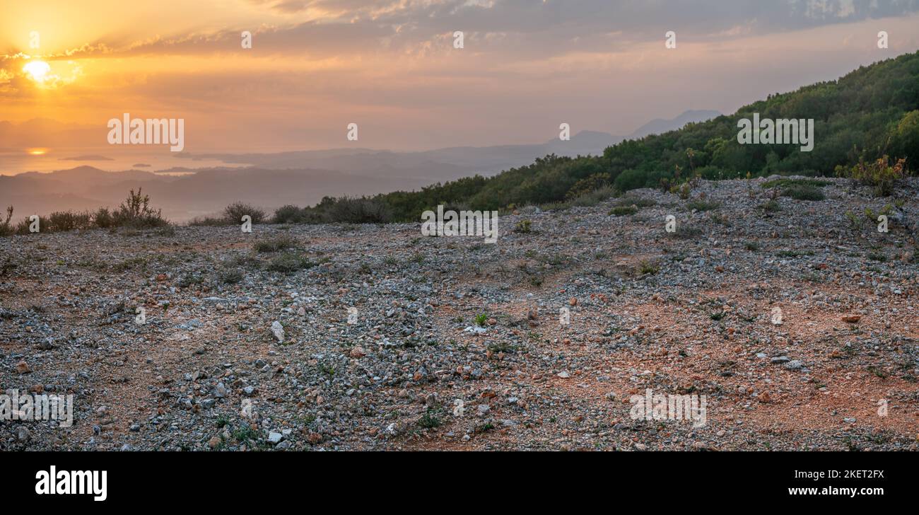 Plaque arrière pour CGI montrant un terrain de stationnement en gravier à un point de vue sur l'île de Corfou pendant un beau lever de soleil Banque D'Images