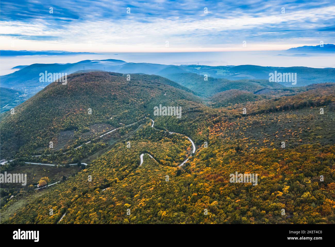 Vue panoramique sur les montagnes couvertes de forêts dans l'aura d'automne. Automne sur les montagnes avec un épais brouillard matinal en arrière-plan. Un windi Banque D'Images