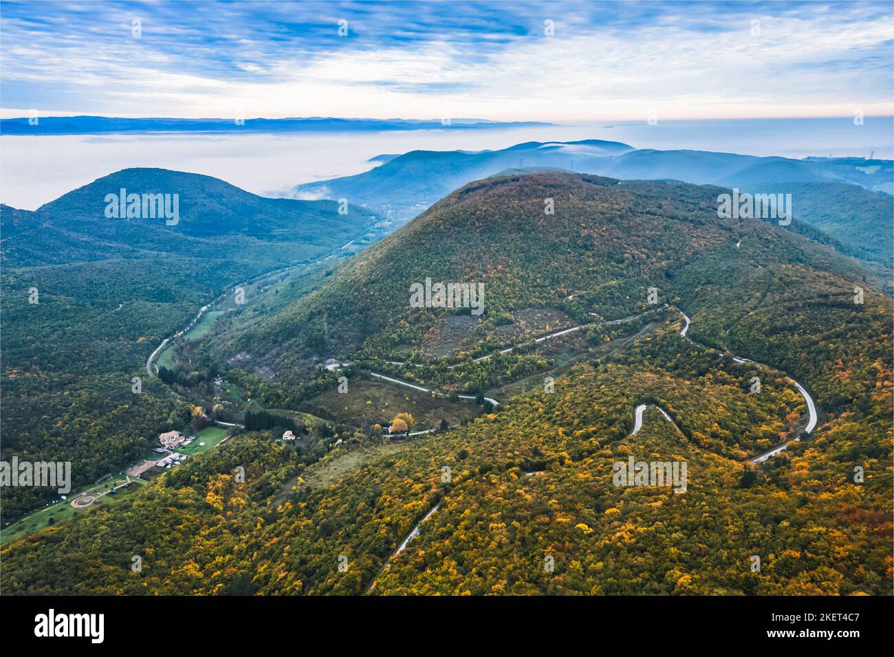 Vue panoramique sur les montagnes couvertes de forêts dans l'aura d'automne. Automne sur les montagnes avec un épais brouillard matinal en arrière-plan. Un windi Banque D'Images